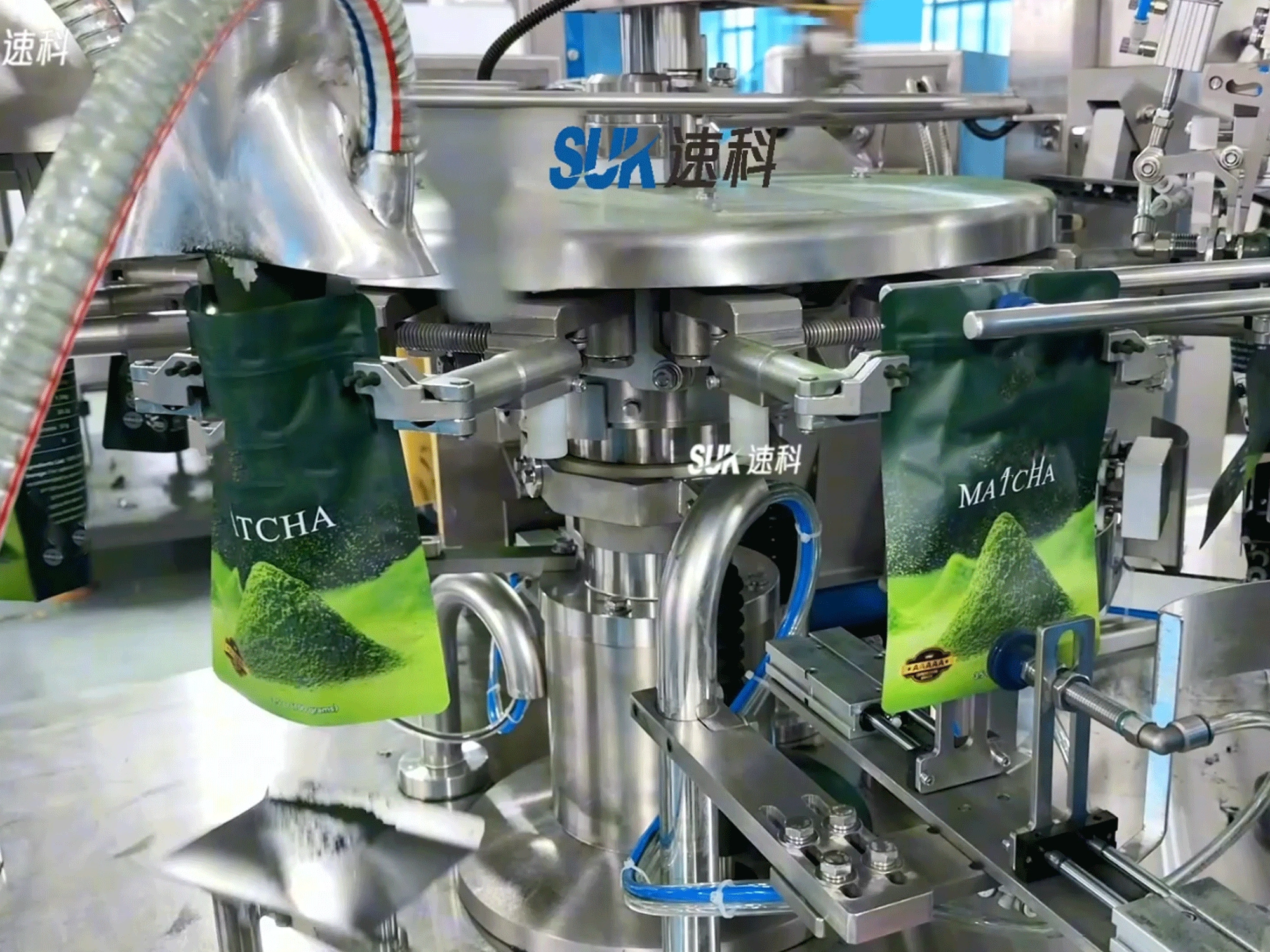 Matcha powder pouches held by grippers at the feeding and filling stations of a pouch packing machine